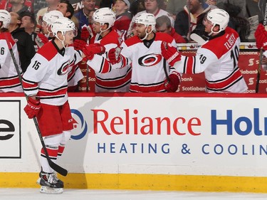Andrej Nestrasil #15 of the Carolina Hurricanes celebrates his first period goal against the Ottawa Senators with teammates at the players' bench.