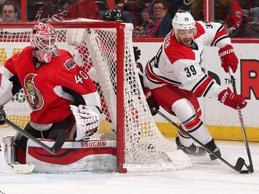 Robin Lehner #40 of the Ottawa Senators guards his net against a wraparound attempt by Patrick Dwyer #39 of the Carolina Hurricanes.