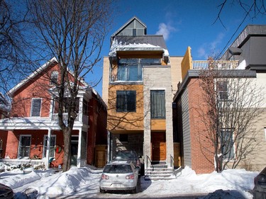 Manufactured stone, traditional cedar and a small veranda with columns help connect the home with its older surroundings. “We wanted to respect the character of the neighbourhood,” says Delahousse. Visible are the dual windows of the second-floor master bedroom overlooking the street and, above that, the generous glazing and balcony of the living room. To the right is the Delahousse’s apartment building.