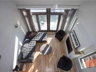 The living room, with its generous seating, reclaimed birch floors from Logs End, floor-to-ceiling windows, and balcony beyond. The gas fireplace is programmable, so while the house is left cool during the winter workday, the main living area has warmed up by the time they get home. The room is the couple’s favourite spot in the house, says Delahousse. “When you’re having coffee on a Saturday morning and the sun comes in, it lights up the whole place.”