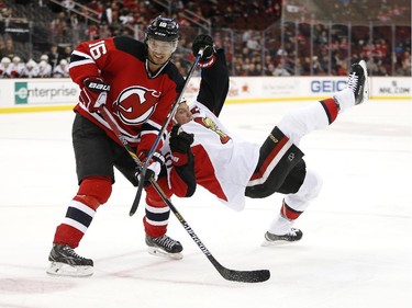 Ottawa Senators right wing Chris Neil, right, falls to the ice while competing for the puck against New Jersey Devils center Jacob Josefson (16), of Sweden, during the second period.