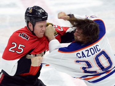 Ottawa Senators' Chris Neil, left, battles it out with Edmonton Oilers' Luke Gazdic during second period NHL hockey action in Ottawa on Saturday, Feb. 14, 2015.