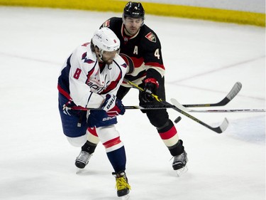 Ottawa Senators defenseman Chris Phillips pressures Washington Capitals left winger Alex Ovechkin (8) as he tries to tip a shot during first period NHL action.
