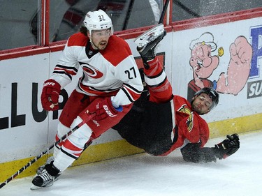 Ottawa Senators' Clarke MacArthur gets hit to the ice by Carolina Hurricanes' Justin Faulk during first period NHL hockey action.