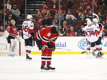 Ottawa Senators players, right, celebrate a goal by Curtis Lazar on New Jersey Devils goalie Cory Schneider, left, during the second period.