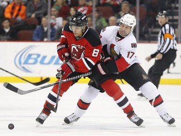 New Jersey Devils right wing Dainius Zubrus (8), of Lithuania, and Ottawa Senators center David Legwand (17) compete for the puck during the first period.