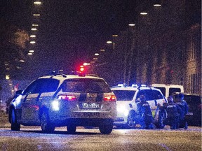Police officers take cover behind their cars on the streets of central Copenhagen on Feb. 15, 2015 after one person was shot in the head and two police officers were shot.