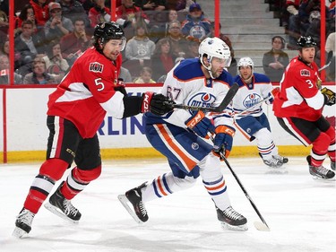 OTTAWA, ON - FEBRUARY 14: Cody Ceci #5 of the Ottawa Senators defends against Benoit Pouliot #67 of the Edmonton Oilers in the first period at Canadian Tire Centre on February 14, 2015 in Ottawa, Ontario, Canada.
