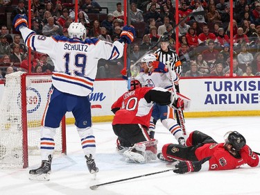 OTTAWA, ON - FEBRUARY 14: Justin Schultz #19 of the Edmonton Oilers celebrates a goal from team mate Derek Roy #8 as Robin Lehner #40 and Bobby Ryan #6 defend the net in the first period at Canadian Tire Centre on February 14, 2015 in Ottawa, Ontario, Canada.