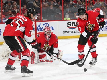 OTTAWA, ON - FEBRUARY 14: Curtis Lazar #27 of the Ottawa Senators clears the rebound as team mates Erik Karlsson #65 and Robin Lehner #40 defend the net against the Edmonton Oilers in the first period at Canadian Tire Centre on February 14, 2015 in Ottawa, Ontario, Canada.