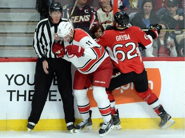 A referee gets caught up in a hit between Ottawa Senators' Eric Gryba, right, and Carolina Hurricanes' Jordan Staal during first period NHL hockey action.