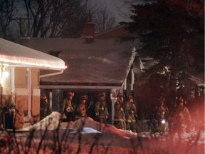 Firefighters outside a home, scene of a fatal fire at 3340 Kodiak St. in Ottawa, Saturday, February 7, 2015. A elderly woman, a heavy smoker who apparently lived alone, was pronounced deceased at the scene.