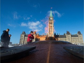 Flames from the Centennial Flame on Parliament Hill rise up in front of the Peace Tower.