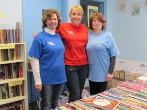 Tricia Carran, from left, Danielle Carrie and Jean Libbey are all smiles after setting up the children's chapter book room for the Kanata Book Fair.