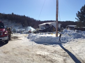 A backhoe clears debrios at the site of the fatal fire in Gracefield, north of Gatineau.