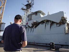 Royal Canadian Navy warship HMCS Algonquin sits in port with significant damage to her port side hangar at CFB Esquimalt in Esquimalt, September 1, 2013 following a collision with the HMCS Protecteur during a close-quarters training exercise.