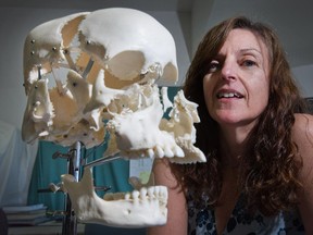 Anthropology researcher Janet Young with a model of a human skull.