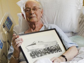 Jim Holt, 79, is photographed in his hospital bed at Elizabeth Bruyere Centre holding a picture of himself when he flew as a jet pilot in the RCAF.