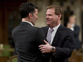 NDP foreign affairs critic Paul Dewar hugs Foreign Affairs Minister John Baird Tuesday, February 3, 2015 in Ottawa after Baird announced he will step down from his position.