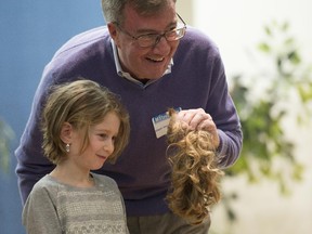 Mayor Jim Watson made the cut for the  Jewish Federation of Ottawa's ninth annual Mitzvah Day. Watson holds the ponytail of proud six-year-old Hoodie Greiniman after cutting her hair, which will be donated to Pantene Beautiful Lengths. Pantene, in partnership with the Canadian Cancer Society, will use the donated hair to make wigs for women with cancer. Mitzvah Day brings the Jewish community together to help those in need by doing good deeds. The mayor was also joined by chief of Police Charles Bourdeleau who cut another girl's hair.