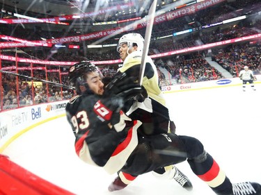 Mika Zibanejad of the Ottawa Senators is hit by Simon Despres of the Pittsburgh Penguins during first period of NHL action at Canadian Tire Centre in Ottawa, February 12, 2015.