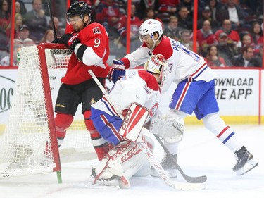 Milan Michalek, left, of the Ottawa Senators is hit by Max Paciorety of the Montreal Canadiens as goalie Dustin Tokarski is caught in the action during first period NHL action.