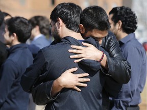 Mourners embrace before the funerals of Deah Shaddy Barakat, 23; his 21-year-old wife of less than two months, Yusor Mohammad; and her 19-year-old sister, Razan Mohammad Abu-Salha, at the Method Road Soccer Complex, Thursday, Feb. 12, 2015, on the North Carolina State campus in Raleigh, N.C.