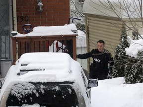 OPP police officer outside a home at 130 Doane St. in Ottawa, Friday, February 20, 2015. Several raids were apparently done early in various locations this morning, a joint operation by Ottawa and OPP police services, also involving tactical officers. Mike Carroccetto / Ottawa Citizen