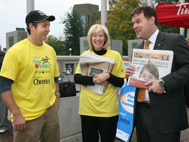 2006: Leonard Asper, President and CEO, CanWest Global Communications Corporation, left; Laureen Harper, wife of Prime Minister, Stephen Harper; and MP John Baird, President of the Treasury Board, hawk newspapers, during the 5th annual Raise-A-Reader, to raise money for children's literacy, September 28, 2006.