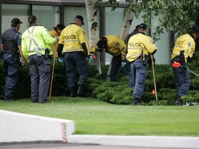 Police search the area around 1510 Riverside Drive on June 30, 2007, after the killings of retired tax court judge Alban Garon, his wife, Raymonde, and their neighbour Marie-Claire Beniskos.