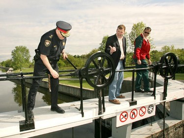 2008: Environment Minister John Baird, centre, points to Ottawa Police Chief Vernon White's superior lockmaster skills as the pair open the gates on the Rideau Canal at Hogs Back Lockstation, May 20, 2008. It was the official launch of the 176th season of uninterrupted service of the Rideau Canal and its first operating season as a World Heritage Site.