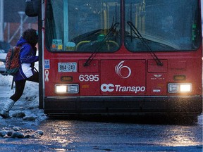 OTTAWA, ONTARIO: JANUARY 6, 2014 --  A bus rider navigates a large puddle to board a bus at Meadowlands Drive and Woodroffe Av as the region experiences freezing rain and melting snow conditions. (Wayne Cuddington / Ottawa Citizen) 115682 ORG XMIT: POS1401060745317741