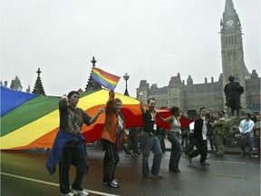 Marchers carry the enormous rainbow Pride flag along Wellington Street. The banner and other memorabilia is in limbo because of the bankruptcy of Capital Pride in December.