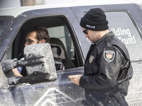 Ottawa Police Constable Jonathan Hall talks to a driver who was pulled over for using his cellphone while driving on St. Laurent Boulevard in Ottawa.