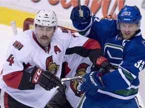 Senators defenceman Chris Phillips, seen with the Canucks' Henrik Sedin in a file photo, is currently tied with Daniel Alfredsson for most games played in a Senators uniform. Phillips says he's proud and honoured to be in Alfie's company.