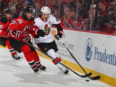 Erik Karlsson #65 of the Ottawa Senators and Jaromir Jagr #68 of the New Jersey Devils battle for a loose puck.