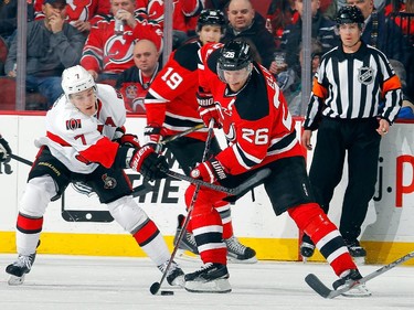 Patrik Elias #26 of the New Jersey Devils controls the puck in the first period against Kyle Turris #7 of the Ottawa Senators.