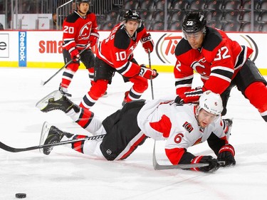 Mark Fraser #32 of the New Jersey Devils commits a tripping penalty in the first period against Bobby Ryan #6 of the Ottawa Senators.