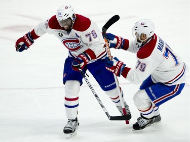 Montreal Canadiens defenseman Andrei Markov helps teammate P.K. Subban off the ice as play continues during second period NHL action. Subban headed to the bench after blocking a shot during the second period.