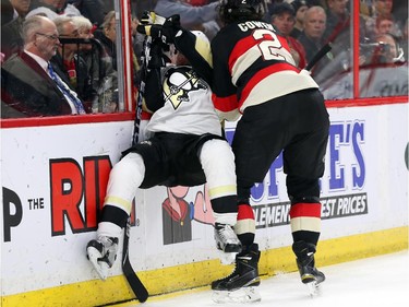 Patric Hornqvist of the Pittsburgh Penguins is hit by Jared Cowen (R)  of the Ottawa Senators during second period of NHL action at Canadian Tire Centre in Ottawa, February 12, 2015.