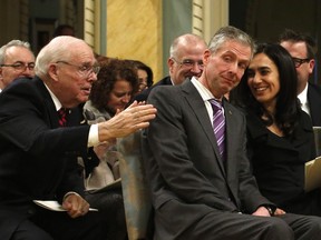 Ian Burney, centre assistant deputy minister of trade and negotiations in the Department of Foreign Affairs, is congratulated by his wife Sylvie Tabet and father Derek Burney (left) after receiving the Outstanding Achievement Award at Rideau Hall Friday. Derek Burney received the same award in 1992.