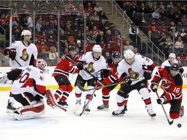 New Jersey Devils center Jacob Josefson (16), of Sweden, reaches for the puck while attacking on the net of Ottawa Senators goalie Robin Lehner (40), of Sweden, during the second period.