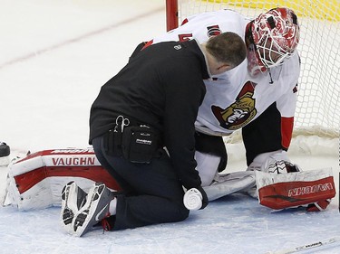 Ottawa Senators goalie Robin Lehner (40), of Sweden, is checked by a trainer during the third period.
