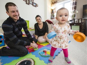 Simon and Melanie Lapointe play with their daughter, Olivia Mae, in their Orleans home Monday.