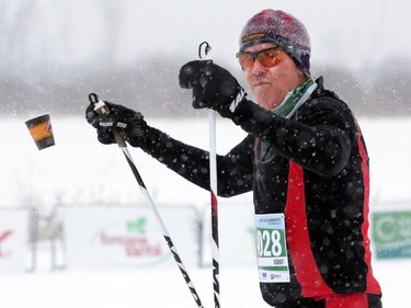 Skier Robert Underwood (4028) tosses a water cup during the Gatineau Loppet in Gatineau, Saturday, February 14, 2015. Competitors braved falling snow plus bone-chilling temperatures to participate in today's event, which started at 9am.