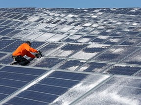 A maintenance man works on solar panels at Norsol solar energy company in Villaldemiro, northern Spain, on February 10, 2015.