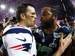 GLENDALE, AZ - FEBRUARY 01: Tom Brady #12 of the New England Patriots is congratulated by Michael Bennett #72 of the Seattle Seahawks  after Super Bowl XLIX at University of Phoenix Stadium on February 1, 2015 in Glendale, Arizona. The Patriots defeated the Seahawks 28-24.