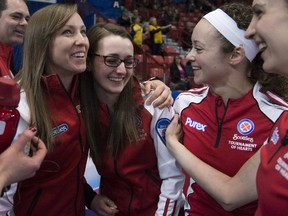 Team Canada skip Rachel Homan, left, hugs alternate Cheryl Kreviazuk as lead Lisa Weagle and second Joanne Courtney look on after winning the morning draw against Northern Ontario at the Scotties Tournament of Hearts in Moose Jaw, Sask. Friday, Feb. 20, 2015.