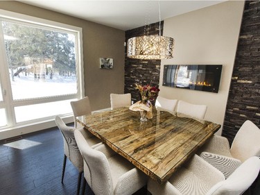 Most of the furniture in the home is from Phillip Van Leeuwen in the ByWard Market. It’s where Nancy and Jeff say they consistently found pieces with the right mix of contemporary and rustic. The dining table is a case in point, with tempered glass adding a smooth gloss to the rough-hewn wood. Behind the table is a wall of cultured stone from Merkley Supply that separates the dining area from the living room. A horizontal gas fireplace from Harding, operated by a remote, adds a cosy glow.