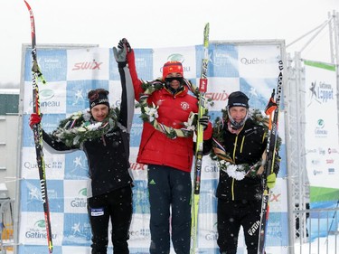 The top-3 finishers Jian He (gold, centre), Nicolas Pigeon (silver, left) and Bruce MacNeil (bronze) pose on the podium after finishing the Gatineau Loppet in Gatineau, Saturday, February 14, 2015. Competitors braved falling snow plus bone-chilling temperatures to participate in today's event, which started at 9am.